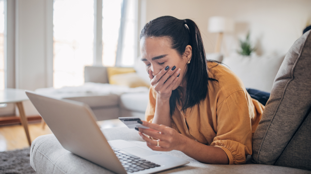 Worried woman with credit card, concerned about fake reviews online