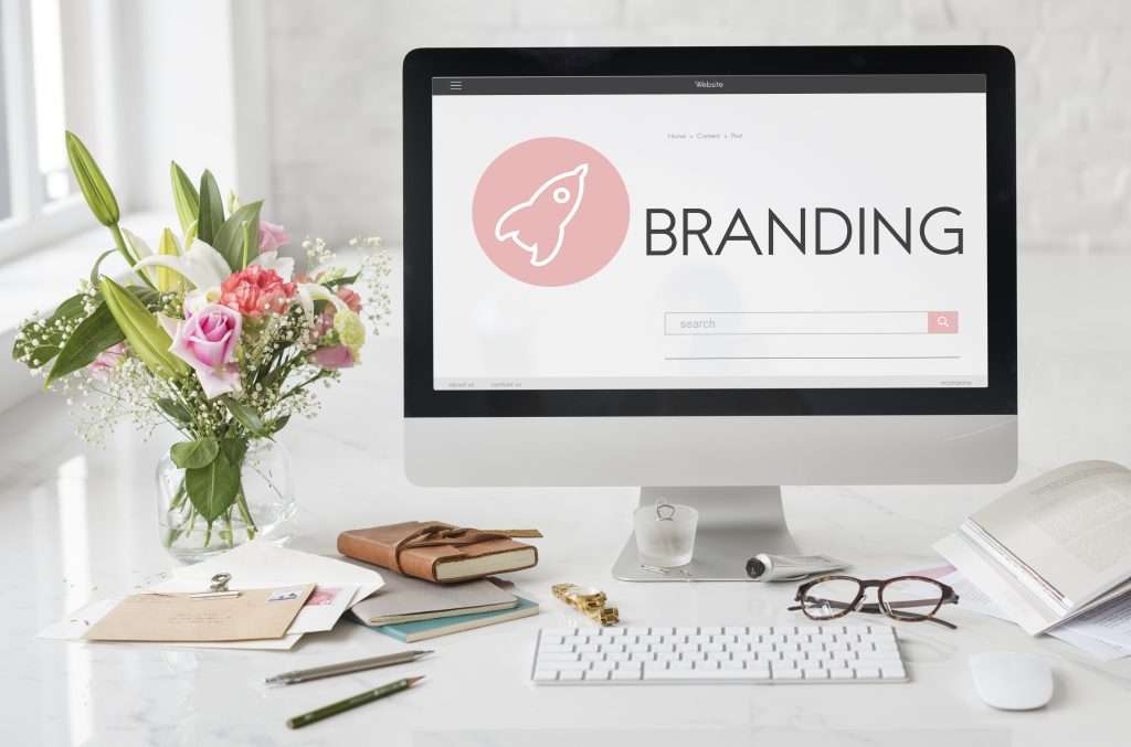 Computer screen displaying branding concept on a workspace