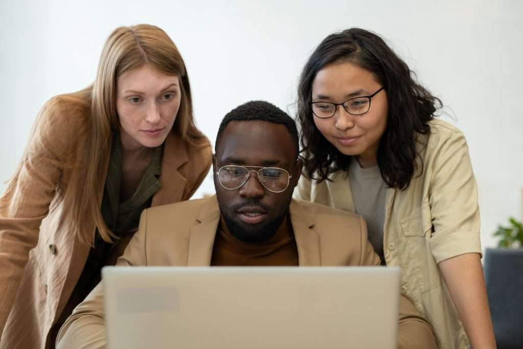 Team collaborating while looking at a laptop screen