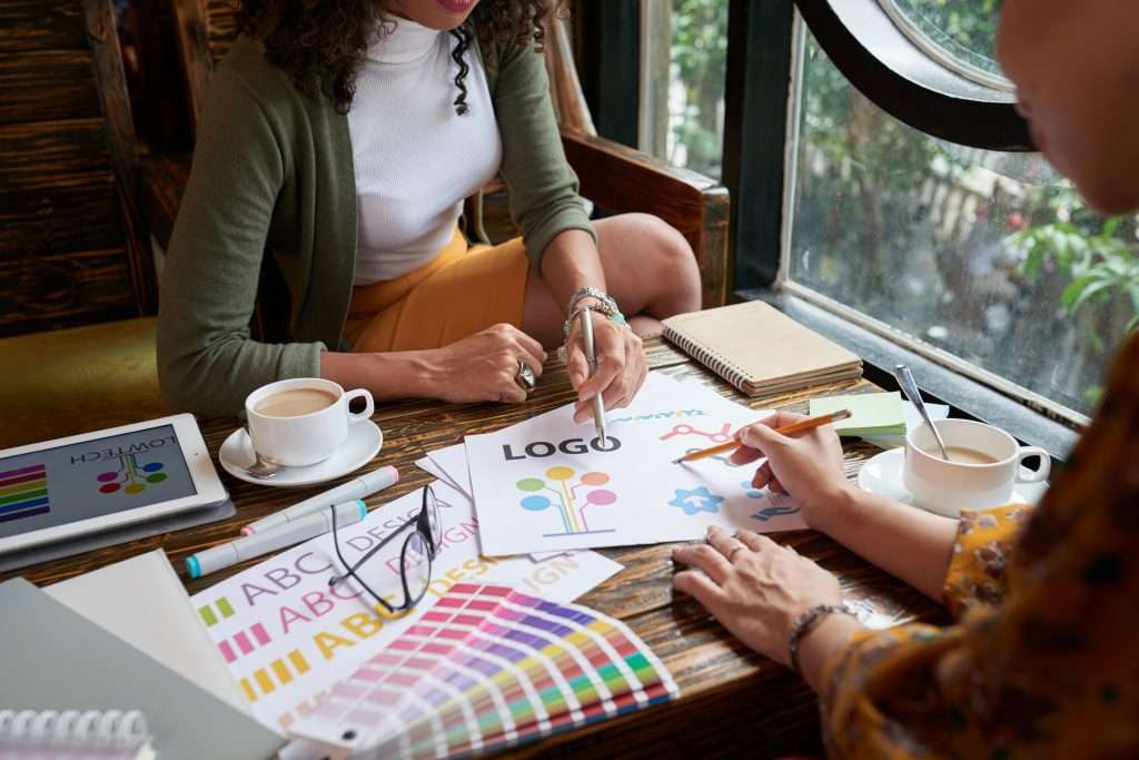 Creative team discussing logo design concepts over coffee