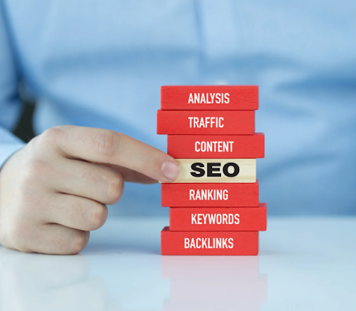 Hand pulling an SEO block from a stack labeled with SEO elements like content, keywords, and backlinks